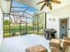 Relaxing screened patio area, featuring an outdoor grill, ceiling fan, and wicker furniture at 501 Heartwell Dr, Poinciana, FL 34759