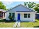 Charming single-story home with a blue front door, white picket fence, and well-maintained lawn at 516 W 7Th St, Lakeland, FL 33805