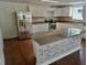Updated kitchen featuring granite counters, white cabinets, an island with a bar, and stainless appliances at 516 W 7Th St, Lakeland, FL 33805