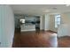 Open-concept living space with hardwood floors, white walls, and an integrated kitchen area at 516 W 7Th St, Lakeland, FL 33805