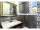 Stylish bathroom featuring dark wood vanity, granite countertop, and patterned shower curtain at 5641 Orange Ave, Intercession City, FL 33848