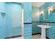 Beautiful bathroom with turquoise tile, pedestal sink, and walk-in shower at 5641 Orange Ave, Intercession City, FL 33848