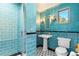 Unique bathroom featuring vibrant blue tiling, a stylish pedestal sink, and a sleek shower stall at 5641 Orange Ave, Intercession City, FL 33848