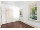 Elegant bedroom with hardwood floors, white trim, and a door leading to a charming porch area at 5641 Orange Ave, Intercession City, FL 33848