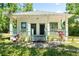 Inviting home with a covered porch, green trim, and a welcoming walkway amidst a manicured lawn at 5641 Orange Ave, Intercession City, FL 33848