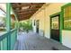 Charming porch with painted wood flooring and black door under a rustic metal roof at 5641 Orange Ave, Intercession City, FL 33848