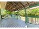 Relaxing porch with wood flooring and decorative green trim under a rustic metal roof at 5641 Orange Ave, Intercession City, FL 33848