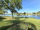 Well-maintained backyard with lush green lawn and serene lake view at 585 Grand Canal Dr, Poinciana, FL 34759