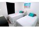 Comfortable bedroom with two twin beds, beach themed art, and a dark accent wall at 585 Grand Canal Dr, Poinciana, FL 34759