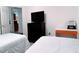 Well-lit bedroom with two twin beds, a dark dresser, and an adjacent kitchen at 585 Grand Canal Dr, Poinciana, FL 34759