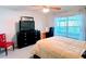 Cozy bedroom featuring a ceiling fan, a desk, and natural light from a window at 585 Grand Canal Dr, Poinciana, FL 34759