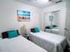 Inviting bedroom featuring two twin beds, mirrored closet, and beach-themed decor at 585 Grand Canal Dr, Poinciana, FL 34759