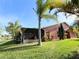 Home exterior with well-maintained lawn and screened patio area at 585 Grand Canal Dr, Poinciana, FL 34759