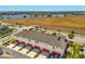 Aerial view of townhomes surrounded by a lush landscape and lake views at 7063 Nemours Pkwy, Orlando, FL 32827