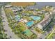 Beautiful aerial view of resort-style community featuring multiple pools, amenities, lush landscaping, and lakeside views at 7063 Nemours Pkwy, Orlando, FL 32827