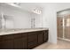 Modern bathroom features a double vanity with granite countertops and a glass-enclosed shower at 7063 Nemours Pkwy, Orlando, FL 32827