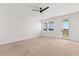 Spacious bedroom with lots of natural light, neutral carpet, and a ceiling fan at 7063 Nemours Pkwy, Orlando, FL 32827