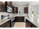 Well-lit kitchen features stainless steel appliances, dark cabinets, tile backsplash, and granite countertops at 7063 Nemours Pkwy, Orlando, FL 32827