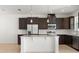 Modern kitchen features dark wood cabinets, stainless steel appliances, granite countertops and a central island at 7063 Nemours Pkwy, Orlando, FL 32827