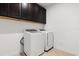The laundry room provides a new washer and dryer and upper storage at 7063 Nemours Pkwy, Orlando, FL 32827