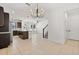 Open-concept living room featuring tile flooring, modern light fixtures, and a staircase at 7063 Nemours Pkwy, Orlando, FL 32827