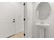 Clean powder room features a pedestal sink, white walls, and tile flooring at 7063 Nemours Pkwy, Orlando, FL 32827