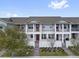 Townhomes with white trim, a private patio, and red front doors at 7063 Nemours Pkwy, Orlando, FL 32827