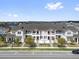 Charming townhomes featuring white trim and red doors with private balconies and landscaped yards at 7063 Nemours Pkwy, Orlando, FL 32827