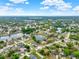 Expansive aerial view showcasing neighborhood's water features, tree coverage, and house rooftops at 780 Kangaroo Ct, Deltona, FL 32738