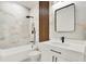 Modern bathroom with a stylish tub, rain shower head, and vanity, featuring marble tile accents and black hardware at 780 Kangaroo Ct, Deltona, FL 32738