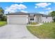 Charming single-story home boasting a manicured lawn, two-car garage, and stylish stone front accents at 780 Kangaroo Ct, Deltona, FL 32738