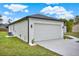 This home features a two-car garage with modern exterior lighting and a well-maintained lawn at 780 Kangaroo Ct, Deltona, FL 32738