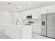 A bright kitchen featuring white cabinetry, stainless steel appliances, and a stylish marble backsplash at 780 Kangaroo Ct, Deltona, FL 32738