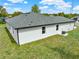 Rear exterior view of home featuring white stucco, new roof, and manicured backyard at 780 Kangaroo Ct, Deltona, FL 32738