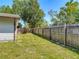 Fenced backyard featuring mature trees and lush green grass in residential home at 11125 Finchley Pl, Orlando, FL 32837