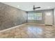 Inviting living area with large windows, tile flooring, a ceiling fan, and a textured accent wall at 11125 Finchley Pl, Orlando, FL 32837