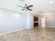 Spacious living area with tiled floors, a ceiling fan, and views into the kitchen at 11125 Finchley Pl, Orlando, FL 32837