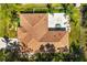 Aerial view of a single-Gathering house featuring a large backyard patio with a hot tub and a well-maintained roof at 1129 Dartford Dr, Kissimmee, FL 34758