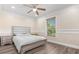 Inviting bedroom with ceiling fan, wood floors, and large window with a serene view at 1129 Dartford Dr, Kissimmee, FL 34758