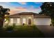Charming single-story home with a well-manicured lawn and inviting curb appeal at sunset at 1129 Dartford Dr, Kissimmee, FL 34758