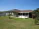 Backyard featuring a spacious lawn, screened patio and partial fencing at 1155 Roan Ct, Kissimmee, FL 34759