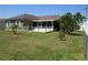 Spacious backyard with mature trees, a screened in patio, and white fencing at 1155 Roan Ct, Kissimmee, FL 34759