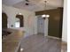 Open-plan living room with tiled floors, neutral paint, arches, and chandelier lighting at 1155 Roan Ct, Kissimmee, FL 34759