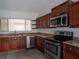 Well-equipped kitchen with stainless steel appliances, granite countertops, and dark wood cabinetry at 12 Robyn Ln, Haines City, FL 33844