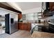Modern kitchen featuring stainless steel appliances, granite countertops, and dark wood cabinets at 12 Robyn Ln, Haines City, FL 33844
