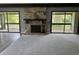 Cozy living room featuring a stone fireplace and sliding doors to a covered patio at 12 Robyn Ln, Haines City, FL 33844