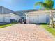 Driveway leading to garages with landscaping and trash bins at 12035 Holystone St, Winter Garden, FL 34787