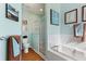 Bright bathroom features a soaking tub, glass-enclosed shower, and tiled accents at 121 Fitzgerald Ln, Davenport, FL 33837