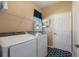 Practical laundry room includes a washer, dryer, storage shelves, and natural light at 121 Fitzgerald Ln, Davenport, FL 33837