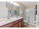 Bathroom featuring a double vanity, custom cabinetry, tile floors, and a glass shower at 1454 Myrtlewood St, Davenport, FL 33896